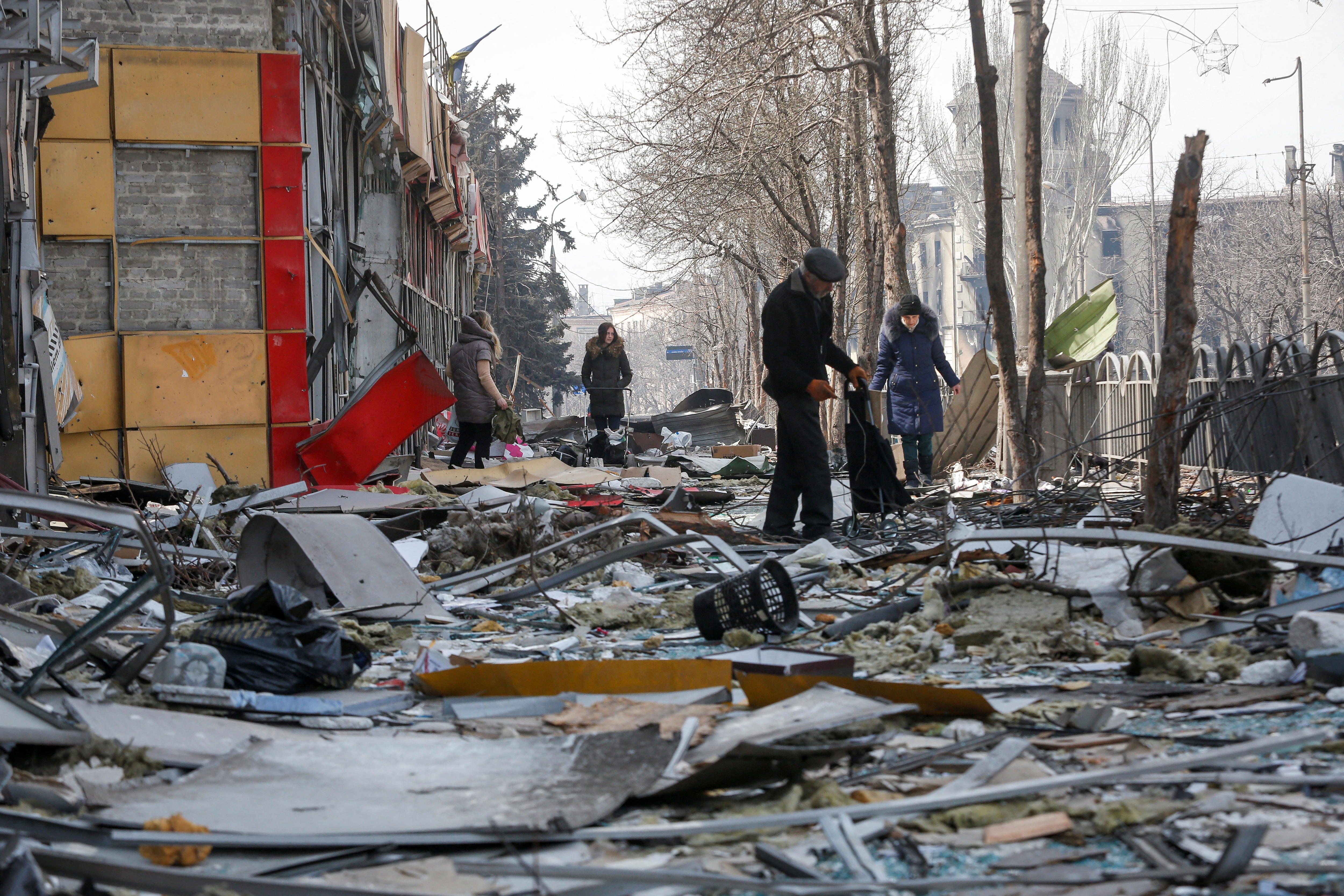 居民走近在乌克兰-俄罗斯冲突过程中被毁的建筑物